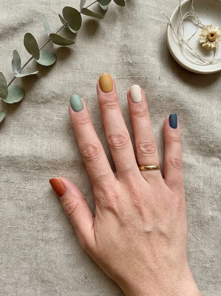 Mismatched skittle manicure with earthy tones.